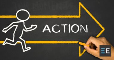 A person drawing with chalk. The drawing is a simple human outline running beside a yellow arrow with the word action in it